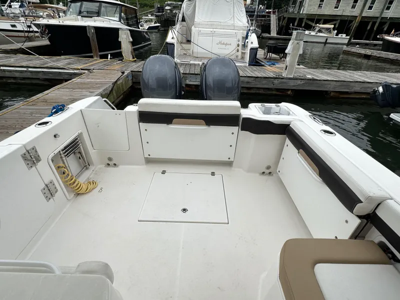 Slide: The Image of 2018 Edgewater 262CX boat interior at dock with twin engines. - 13
