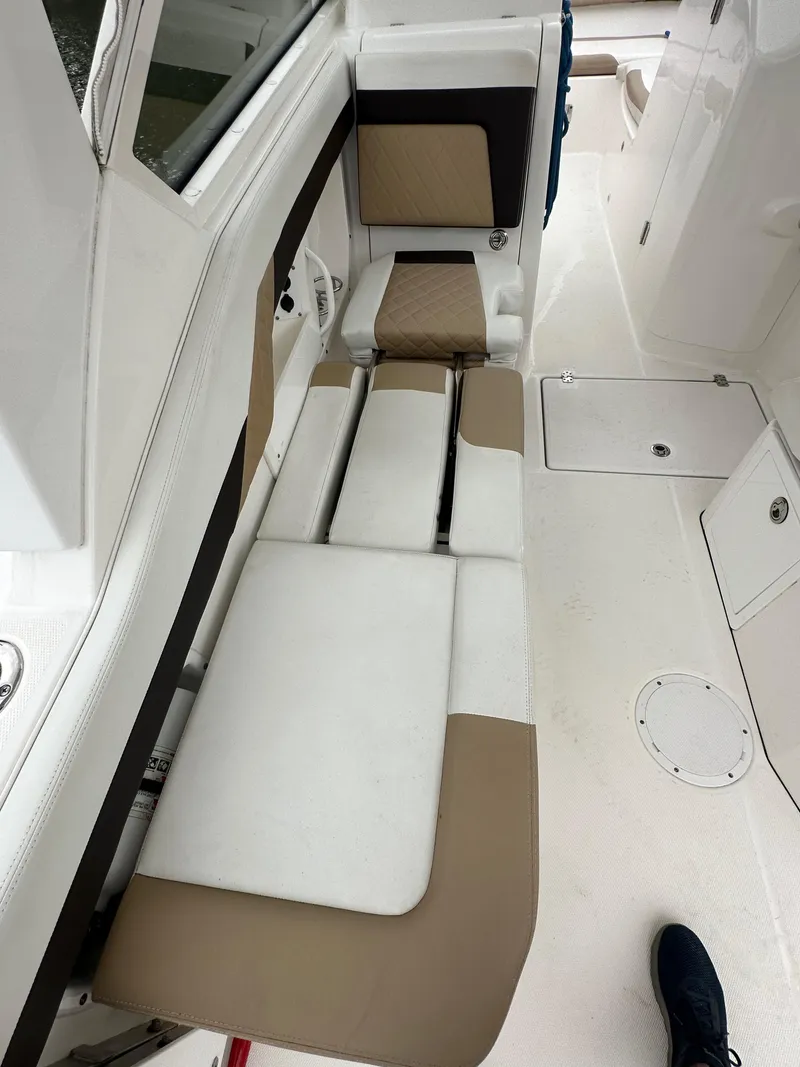 Slide: The Image of 2018 Edgewater 262CX boat interior with beige and white seating. - 14