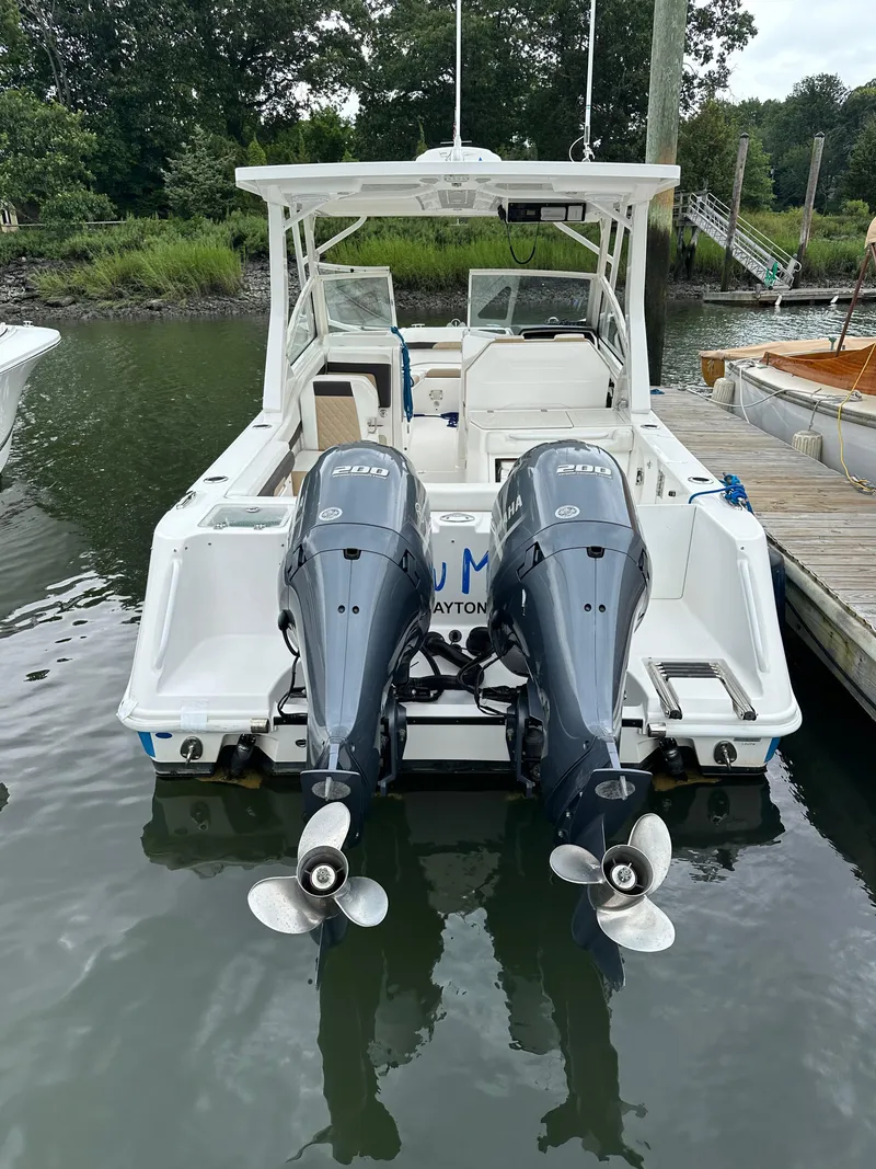Slide: The Image of 2018 Edgewater 262CX boat with twin outboard engines docked. - 2