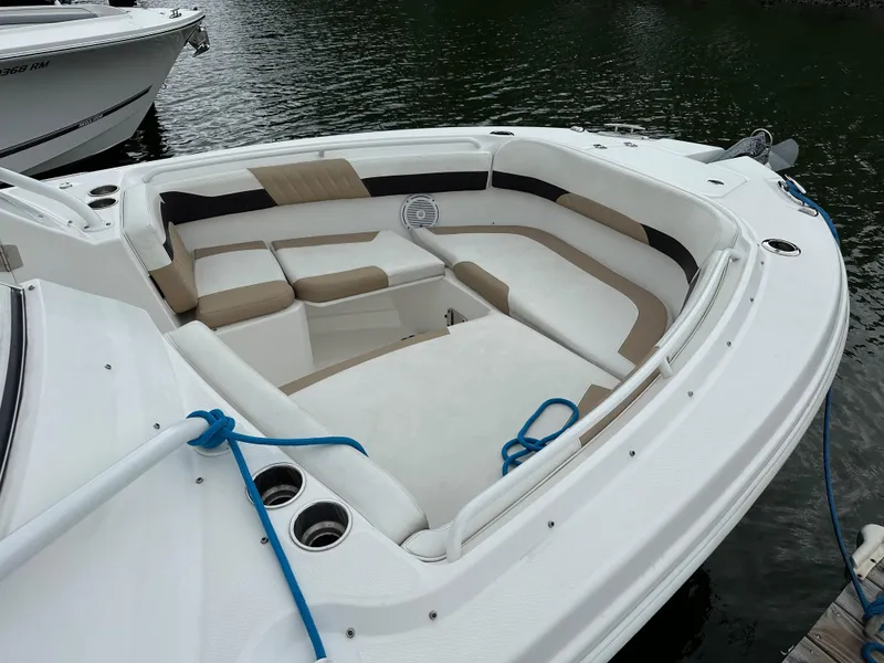 Slide: The Image of 2018 Edgewater 262CX boat with spacious seating area and cup holders, docked on water. - 21