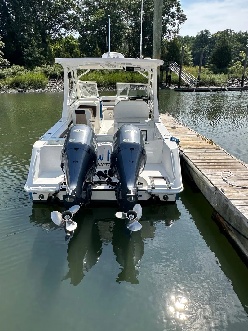 Slide: The Image of 2018 Edgewater 262CX boat docked with twin outboard engines. - 24