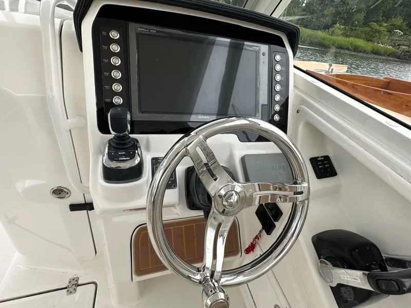 Slide: The Image of 2018 Edgewater 262CX boat helm with steering wheel and navigation system. - 4