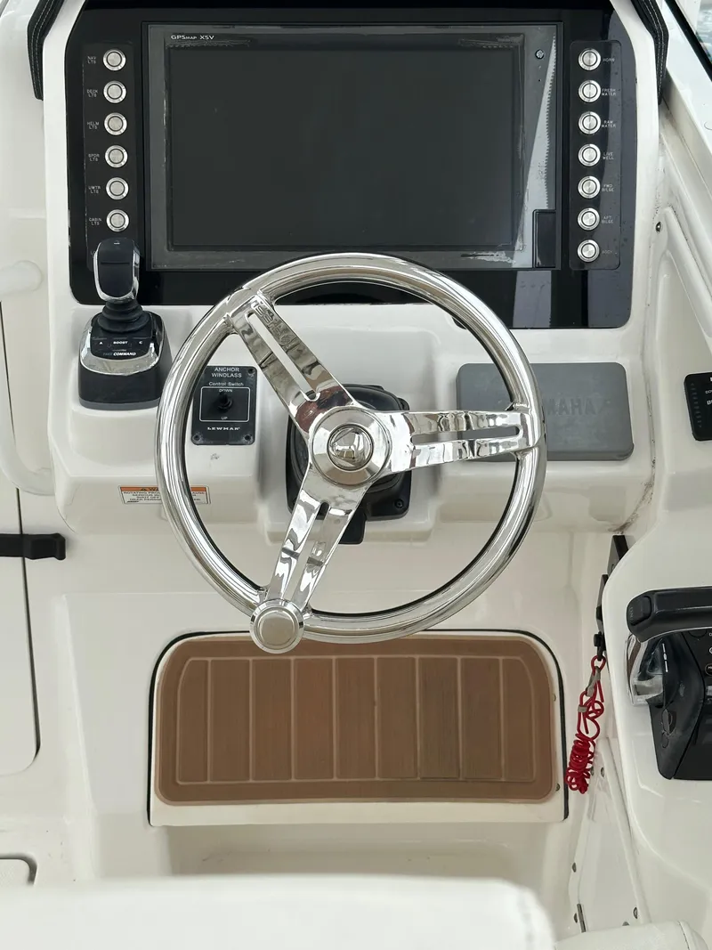 Slide: The Image of 2018 Edgewater 262CX boat helm with steering wheel and control panel. - 7