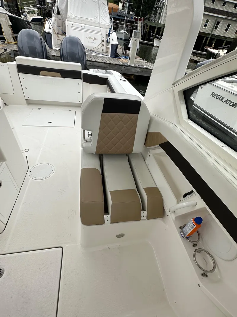 Slide: The Image of 2018 Edgewater 262CX boat interior with beige and black seating. - 8