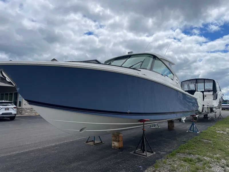 Slide: The Image of 2024 Pursuit DC 326 Dual Console boat on display under cloudy sky. - 1