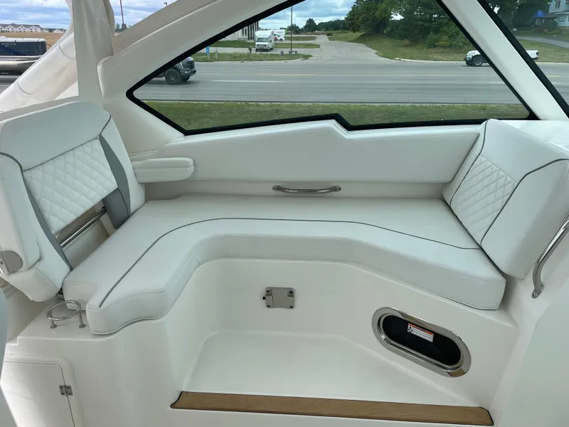 Slide: The Image of 2024 Pursuit DC 326 Dual Console interior with white cushioned seating. - 11