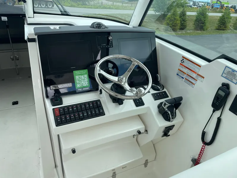 Slide: The Image of 2024 Pursuit DC 326 Dual Console boat dashboard with steering wheel and controls. - 12