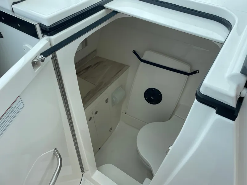 Slide: The Image of 2024 Pursuit DC 326 Dual Console boat interior with compact bathroom amenities. - 16