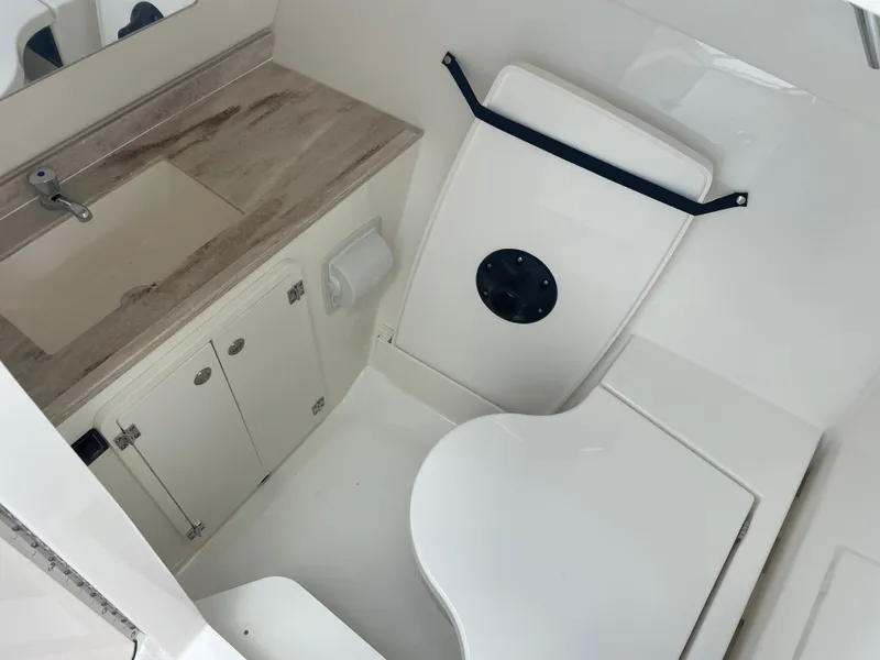 Slide: The Image of 2024 Pursuit DC 326 Dual Console boat bathroom with sink and toilet. - 17