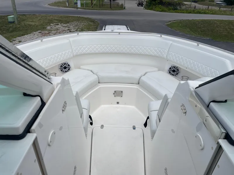 Slide: The Image of 2024 Pursuit DC 326 Dual Console boat interior with white seating and speakers. - 18