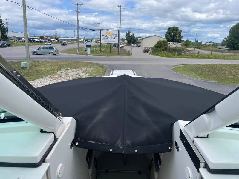 Slide: The Image of 2024 Pursuit DC 326 Dual Console boat with black cover, parked near Washburn Marina. - 23