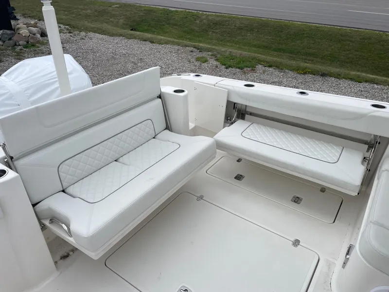 Slide: The Image of 2024 Pursuit DC 326 Dual Console boat with white cushioned seating and spacious deck area. - 7