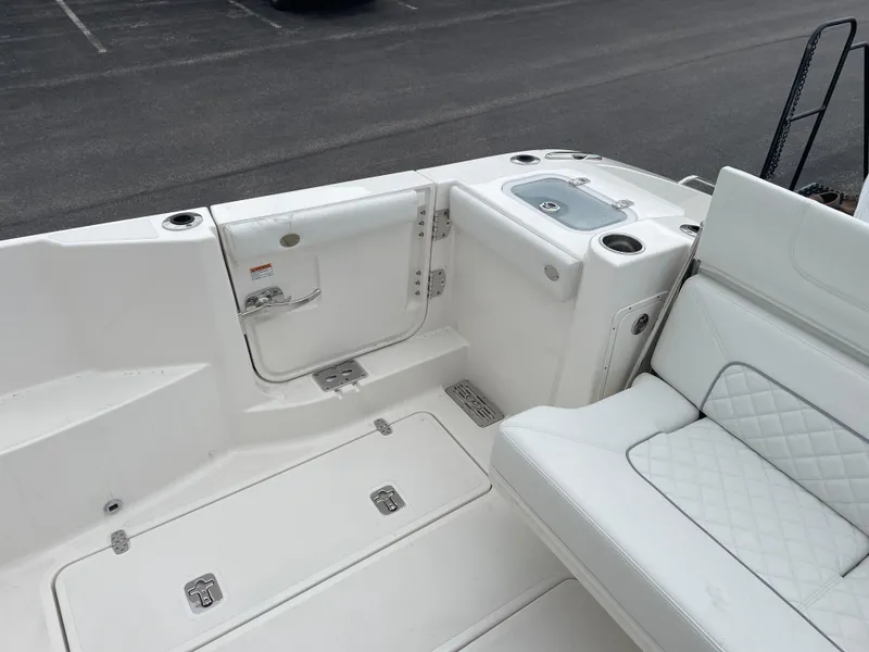 Slide: The Image of 2024 Pursuit DC 326 Dual Console boat interior with white seating and storage compartments. - 8