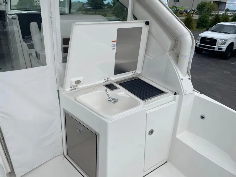 Slide: The Image of 2024 Pursuit DC 326 Dual Console boat with sink and storage area. - 9
