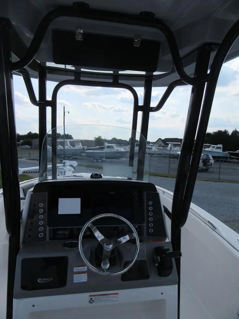 Slide: The Image of 2024 Robalo R230 Center Console boat interior with steering wheel and control panel. - 10