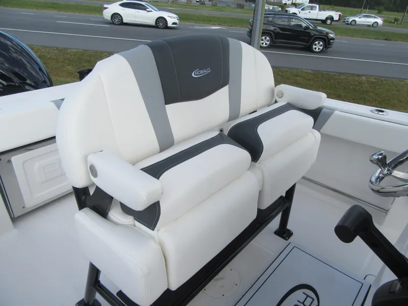 Slide: The Image of 2024 Robalo R230 Center Console boat seating, white and gray upholstery, on a road background. - 12