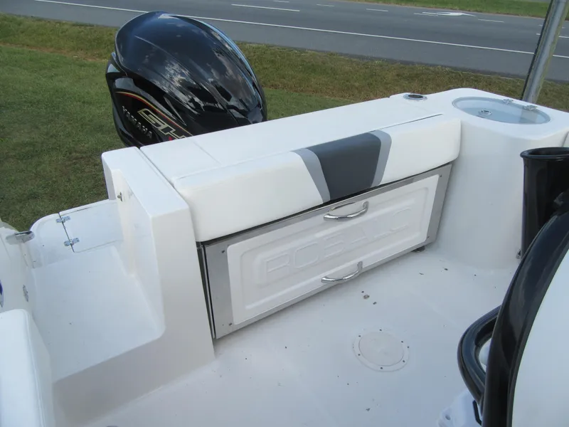 Slide: The Image of 2024 Robalo R230 Center Console boat interior with storage compartment and outboard motor. - 17