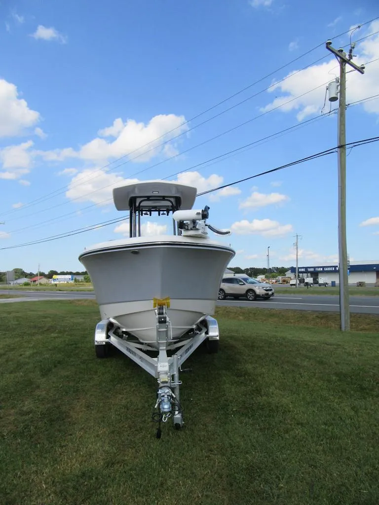 Slide: The Image of 2024 Robalo R230 Center Console boat on trailer, parked on grass under blue sky. - 20