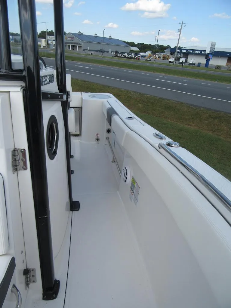 Slide: The Image of 2024 Robalo R230 Center Console boat, side view, near a road. - 8
