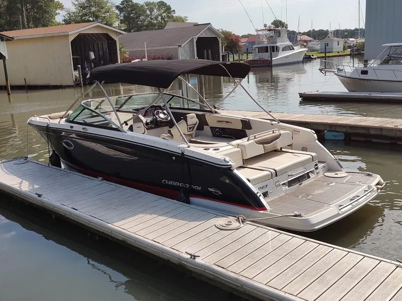 Slide: The Image of 2018 Chaparral 267 SSX boat docked at a marina, featuring sleek design and spacious seating. - 2