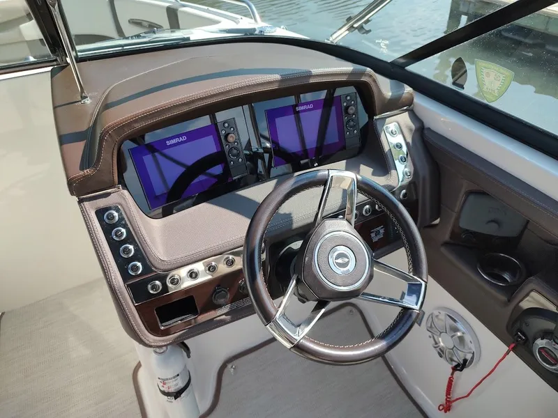 Slide: The Image of 2018 Chaparral 267 SSX boat dashboard with dual Simrad displays and steering wheel. - 30