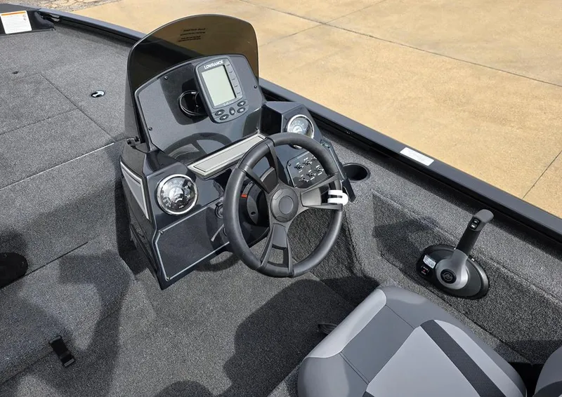 Slide: The Image of 2024 Lowe Stinger 175C boat cockpit with steering wheel and control panel. - 3