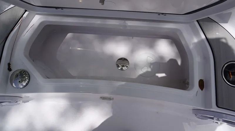 Slide: The Image of 2024 Sportsman 267 Masters OE boat storage compartment, open lid, white interior. - 11