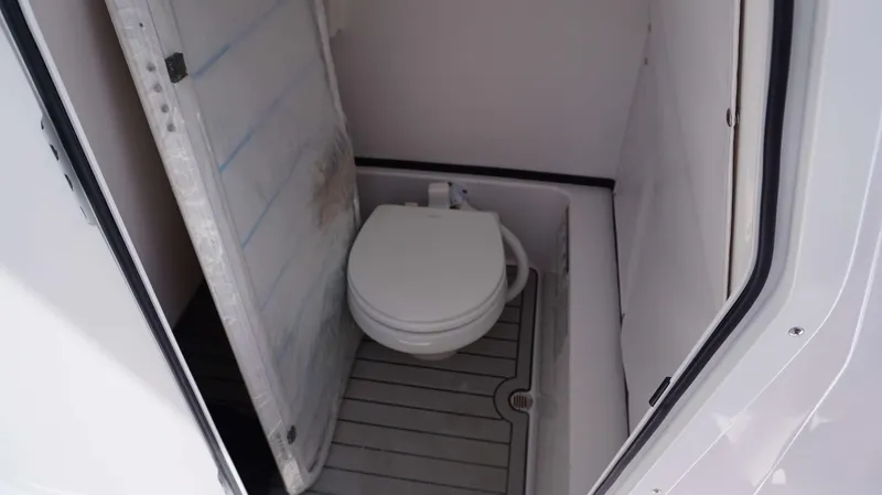 Slide: The Image of 2024 Sportsman 267 Masters OE boat interior with compact marine toilet. - 13