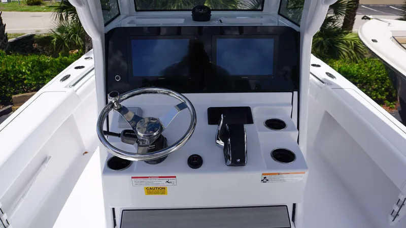 Slide: The Image of 2024 Sportsman 267 Masters OE boat helm with dual screens and steering wheel. - 7
