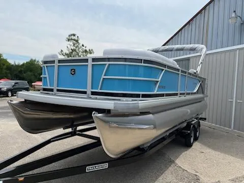 Slide: The Image of 2024 Sweetwater 2286SFL pontoon boat on a trailer outside a metal building. - 1