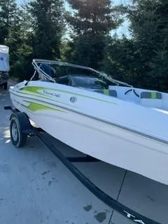 Slide: The Image of 2024 Tahoe T18 boat on trailer, white with green accents, parked outdoors. - 10