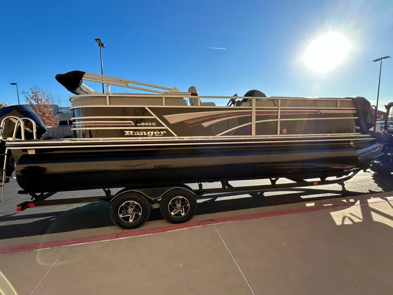 The Image of 2023 Ranger Reata 243C pontoon boat on a trailer. - 0