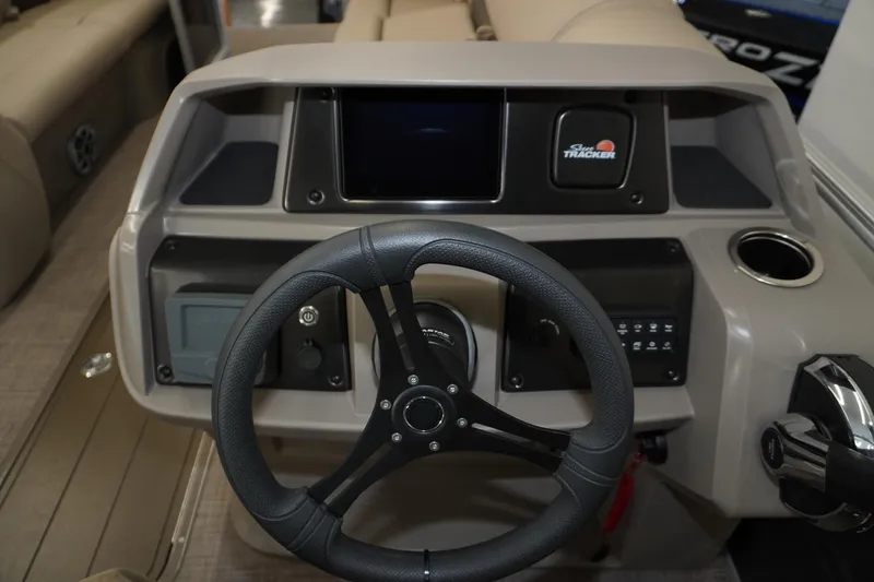 Slide: The Image of 2024 Sun Tracker Party Barge 22 XP3 steering console with modern controls and cup holder. - 9