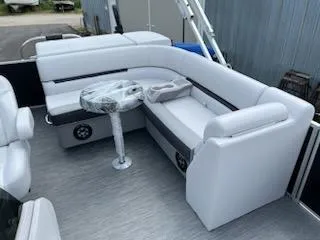 Slide: The Image of 2024 Sweetwater 2286C pontoon boat with white seating and a small table. - 4