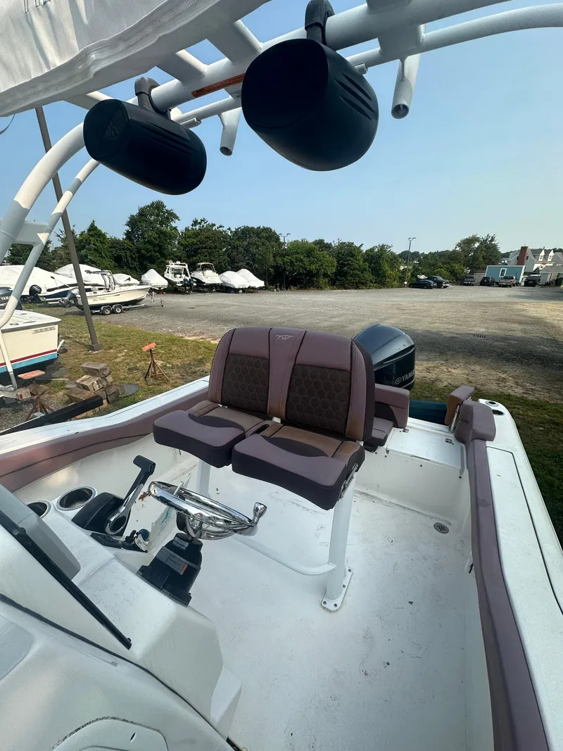 Slide: The Image of 2017 Tidewater 230 LXF boat interior with seating and steering wheel, parked outdoors. - 4