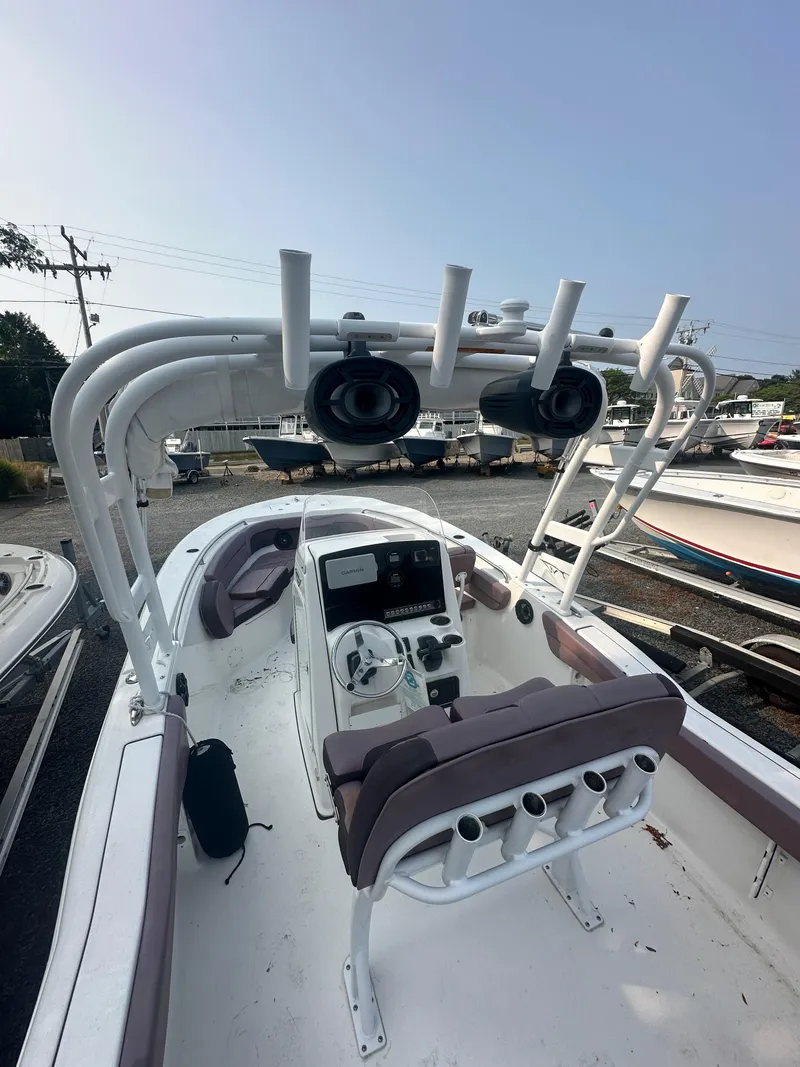 Slide: The Image of 2017 Tidewater 230 LXF boat interior with helm and seating, docked in marina. - 5