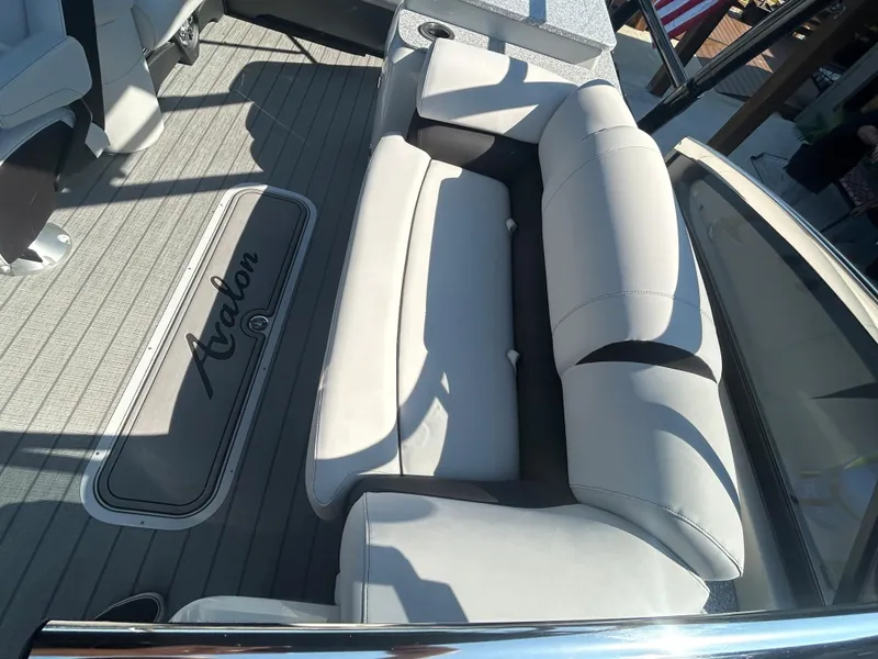 Slide: The Image of 2023 Avalon 2585 EL boat interior with beige seating and logo on floor mat. - 19