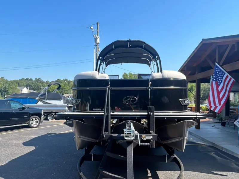 Slide: The Image of 2023 Avalon 2585 EL pontoon boat on trailer, rear view, parked outdoors. - 2