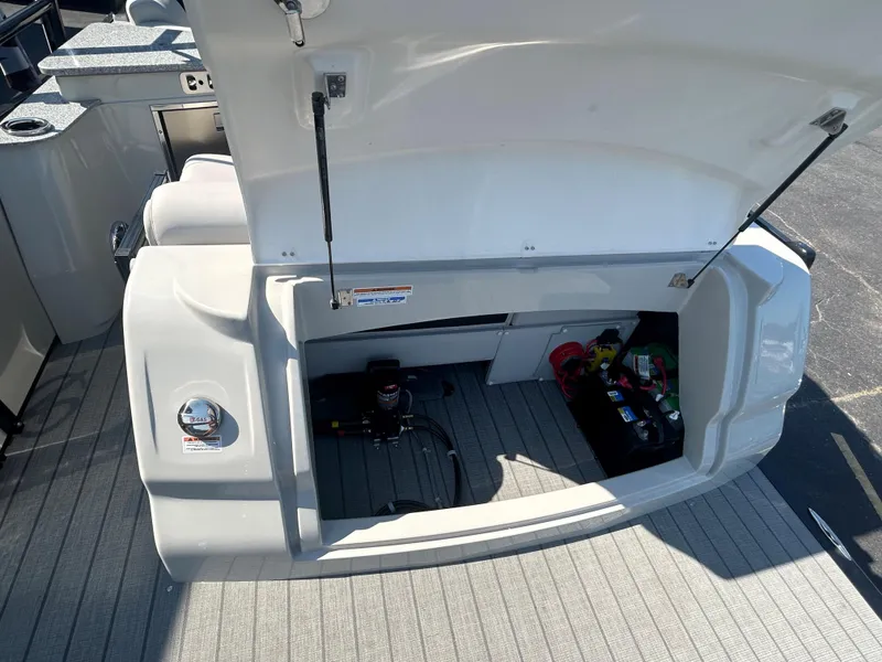 Slide: The Image of 2023 Avalon 2585 EL boat storage compartment with open hatch, revealing equipment and supplies. - 29