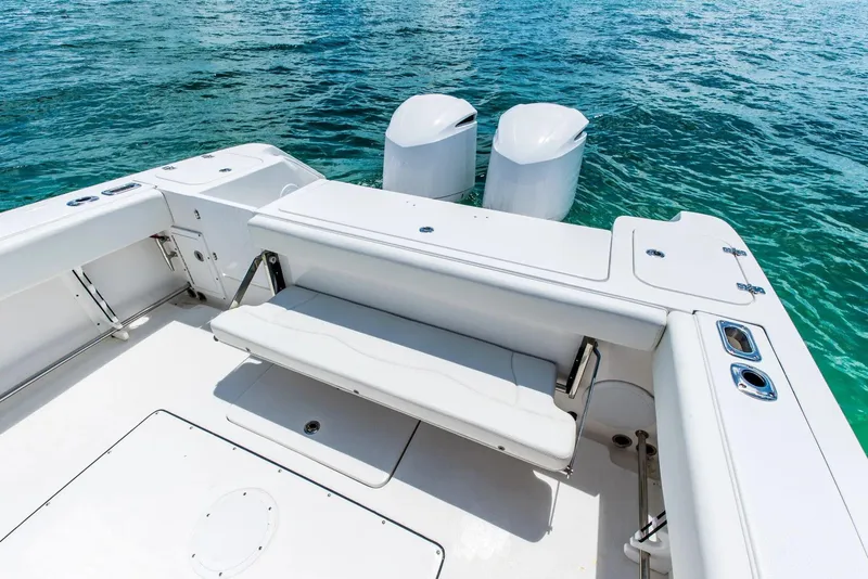 Slide: The Image of 2024 Edgewater 325CC boat with dual outboard motors on clear blue water. - 14