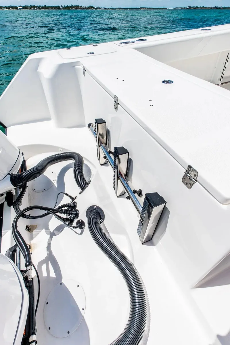 Slide: The Image of 2024 Edgewater 325CC boat deck with fishing equipment and ocean view. - 18