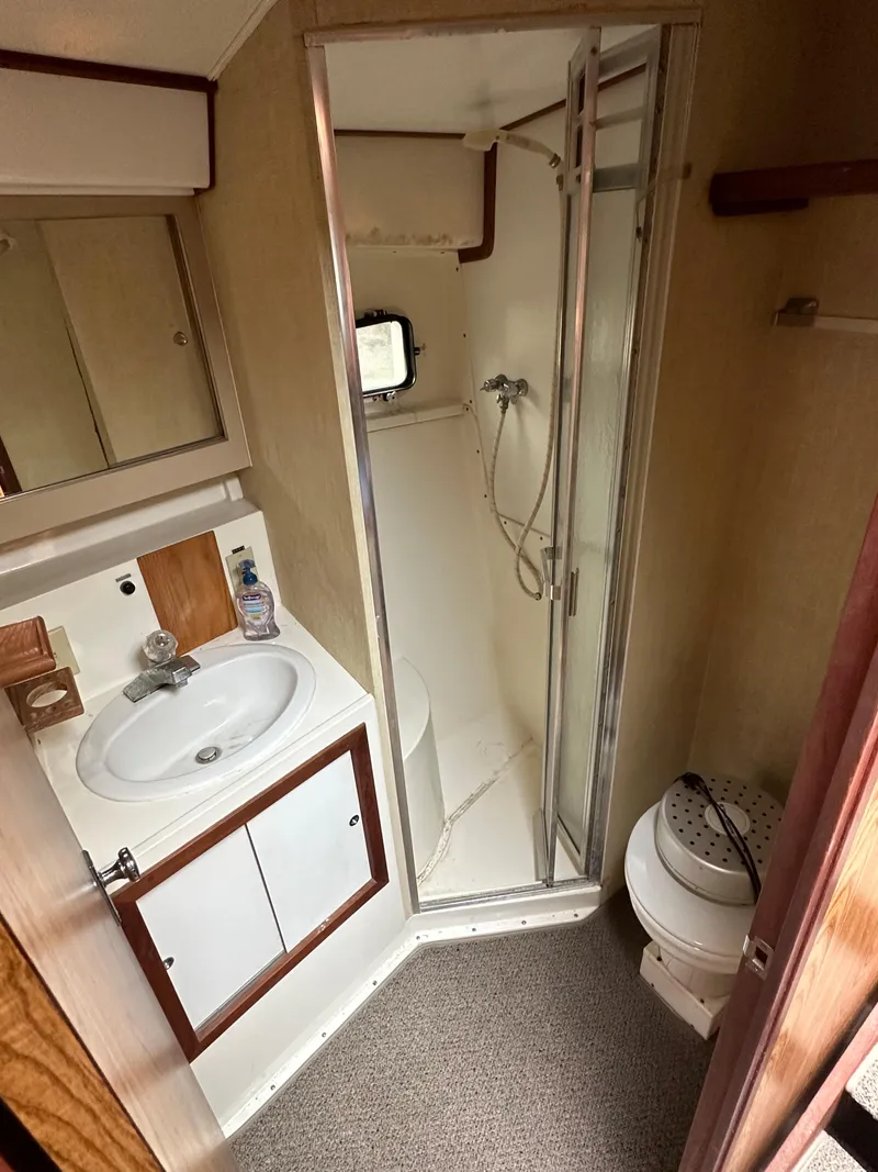 Slide: The Image of 1981 Bertram 38III Convertible bathroom with shower, sink, and toilet. - 12