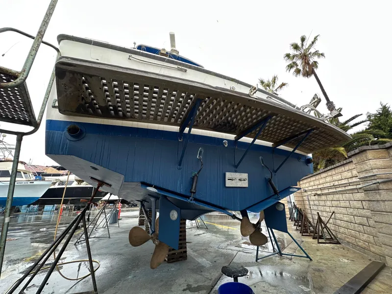 Slide: The Image of 1981 Bertram 38III Convertible boat on dry dock, showing hull and propellers. - 4