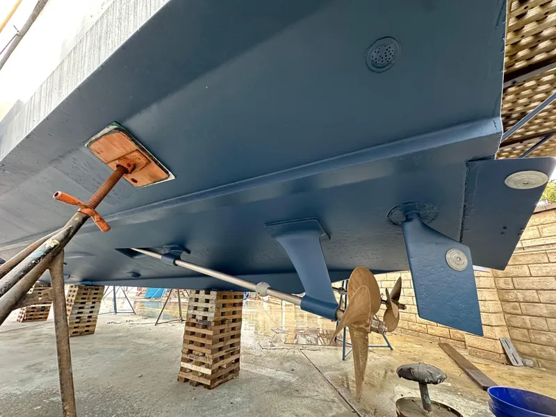 Slide: The Image of 1981 Bertram 38III Convertible boat hull under maintenance, showing propeller and supports. - 5