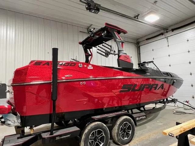 Slide: The Image of 2023 Supra SA boat in a garage, red exterior, on a trailer. - 1