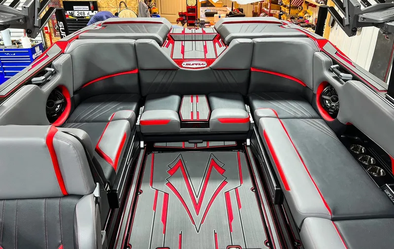 Slide: The Image of 2023 Supra SA boat interior with gray and red seating and stylish flooring. - 10