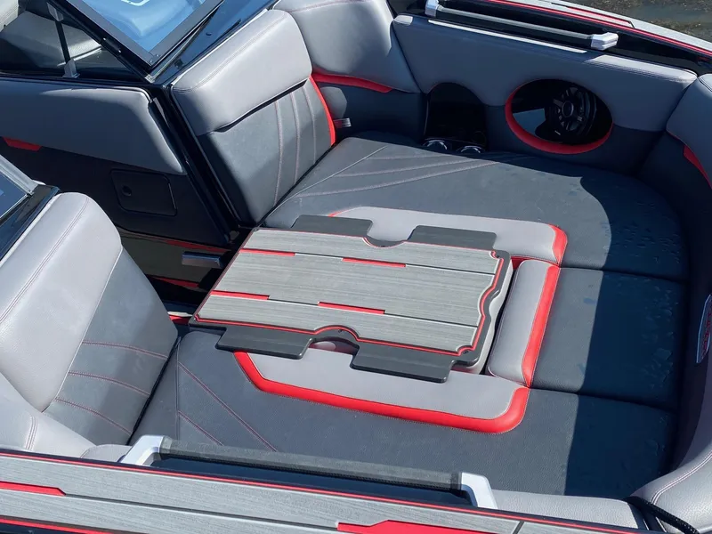 Slide: The Image of 2023 Supra SA boat interior with gray and red seating and a foldable table. - 3