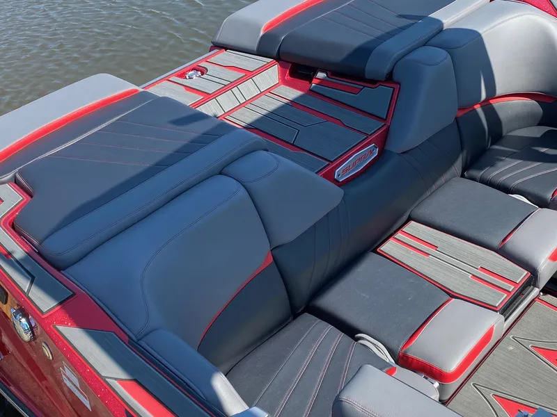 Slide: The Image of 2023 Supra SA boat interior with red and gray upholstery on the water. - 4