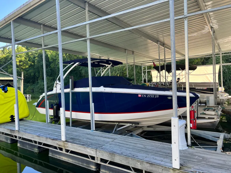 Slide: The Image of 2021 Cobalt R5 boat docked under a covered marina. - 2