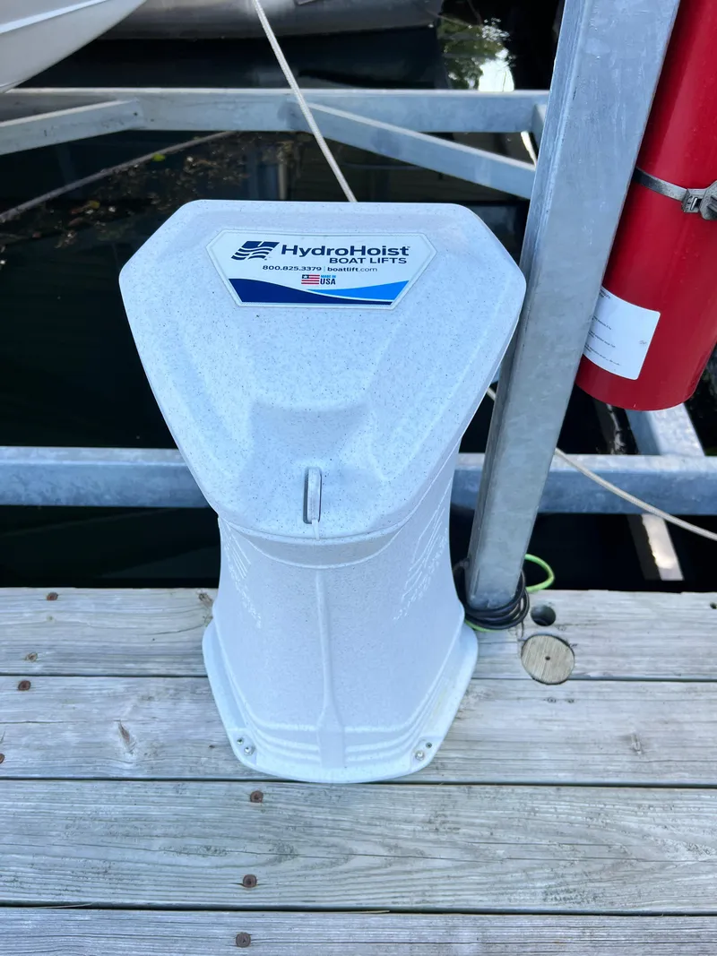 Slide: The Image of HydroHoist boat lift control unit on a wooden dock, near a Cobalt R5 boat. - 21